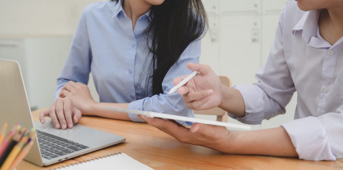 Two women at a table and laptop